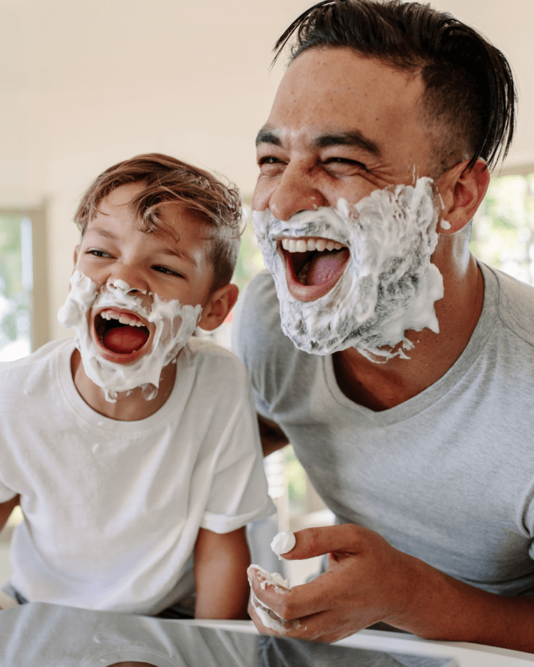 Padre e hijo riendo afeitándose